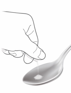 Hand pouring granules from ALKINDI SPRINKLE capsule onto empty spoon